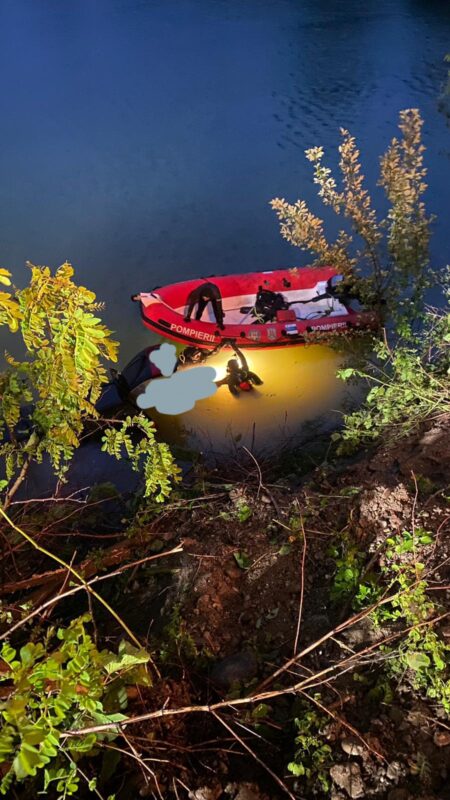 VIDEO | Mașină căzută în balastieră. Șoferul a reușit să se salveze, un pasager este prins în autovehicul