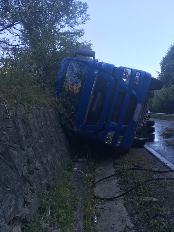 FOTO | Mai ușor în curbe. Un camion cu lemn s-a răsturnat
