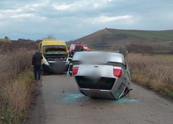 Autoturism răsturnat. Impact cu un microbuz școlar lângă Frata